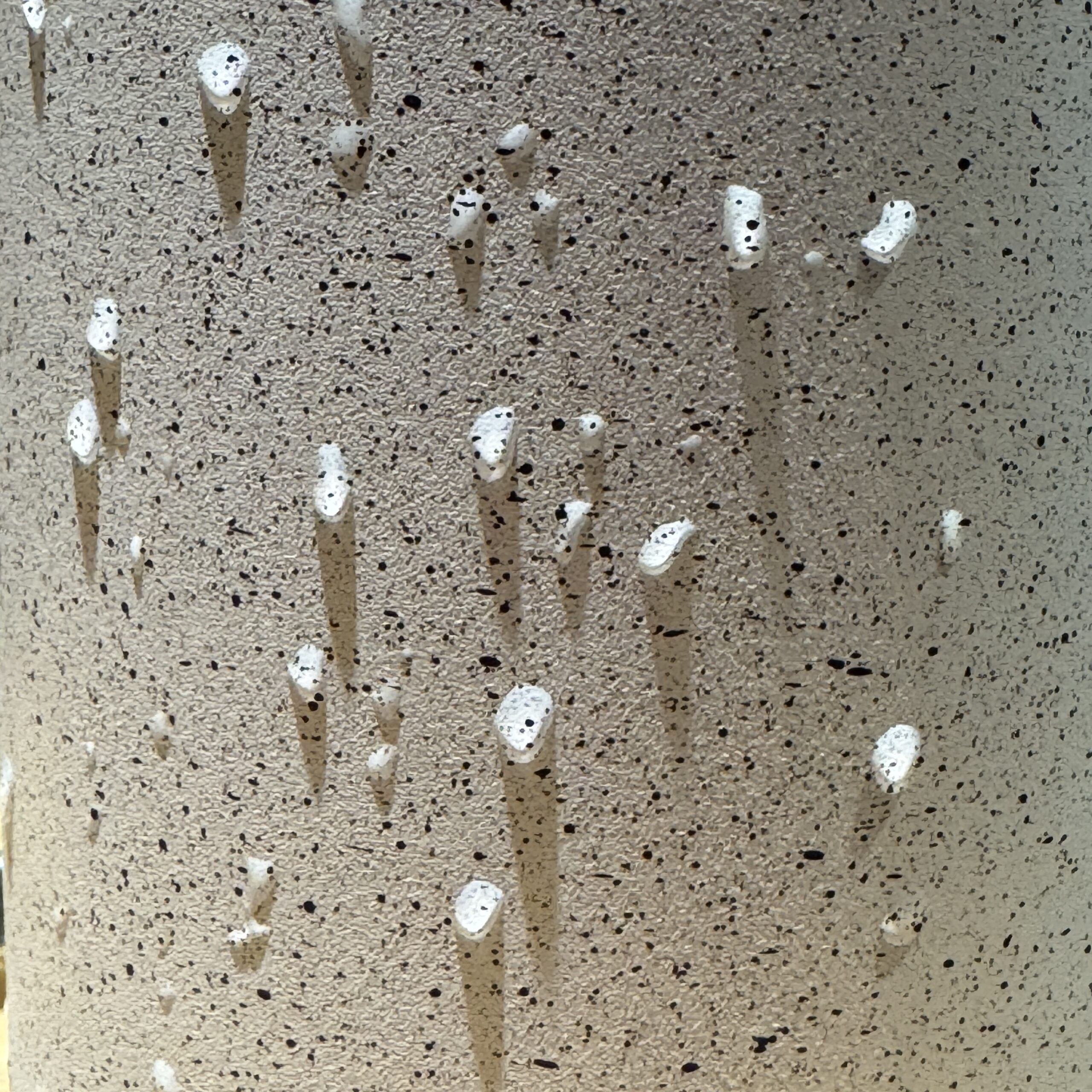 water drops on the side of a speckled mug, much shadowing